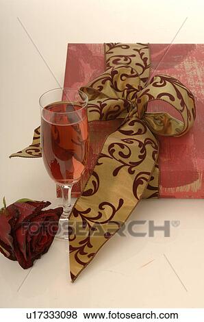 Stock Photo - Arrangement of gifts, rose and glass of sparkling wine. Fotosearch