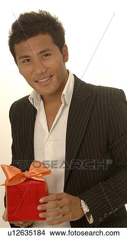 Picture - Asian man with a gift. Fotosearch