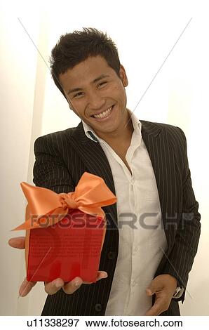 Asian man with a gift View Large Photo Image Stock Photo - Asian man with a gift. Fotosearch