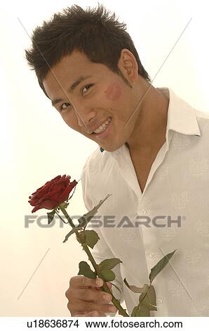 Asian man with a red rose and kissmouth on his check View Large Photo Image Picture - Asian man with a red rose and kissmouth on his check. Fotosearch