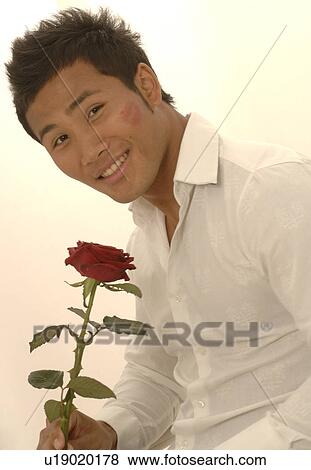 Asian man with a red rose and kissmouth on his check View Large Photo Image Stock Photo - Asian man with a red rose and kissmouth on his check. Fotosearch