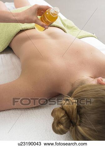 Stock Image - Back massage with massage oil. Fotosearch