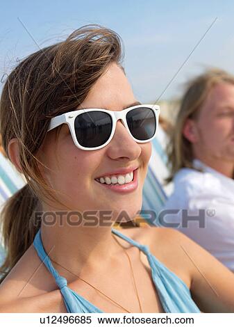 Beautiful young woman with sunglasses taking a sunbath View Large Photo Image Stock Photography - Beautiful young woman with sunglasses taking a sunbath. Fotosearch