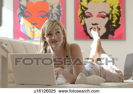 Blonde girl on sofa with laptop View Large Photo Image Stock Photography - Blonde girl on sofa with laptop. Fotosearch