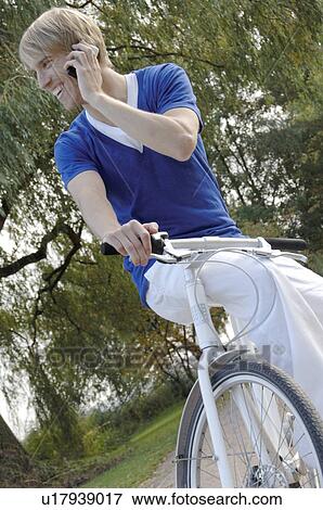 Blonde man with mobile and bicycle View Large Photo Image Stock Photo - Blonde man with mobile and bicycle. Fotosearch