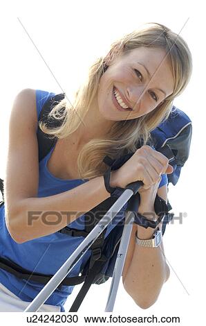 Stock Image - Blonde woman leaning on walking sticks. Fotosearch