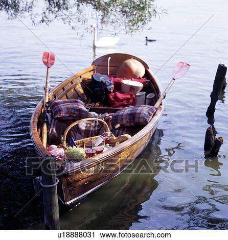 Stock Image - Boat with picnic basket on a lake. Fotosearch