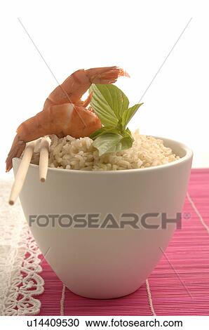 Stock Image - Bowl filled with rice and prawns on top. Fotosearch