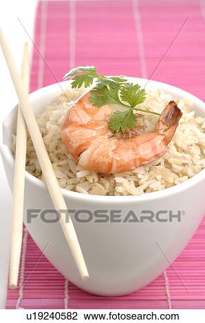 Stock Image - Bowl filled with rice and prawns on top. Fotosearch