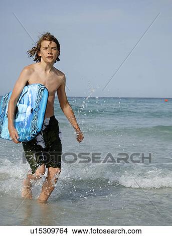 Picture - Boy by the sea with swimming board. Fotosearch