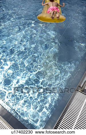Boy floating on airbed in swimming pool View Large Photo Image Stock Image - Boy floating on airbed in swimming pool. Fotosearch