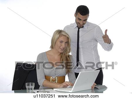 Businessman and woman with laptop at desk View Large Photo Image Stock Image - Businessman and woman with laptop at desk. Fotosearch