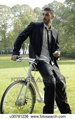 Stock Photograph - Businessman with bicycle and cell phone. Fotosearch