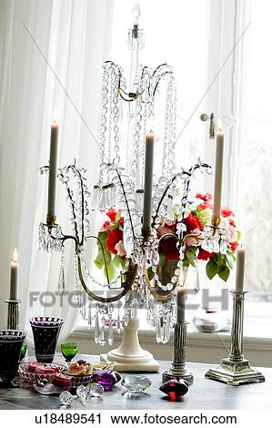 Stock Image - Candleholder and confectionary on sideboard. Fotosearch