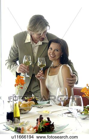 Picture - Couple at a set table with wine glasses. Fotosearch