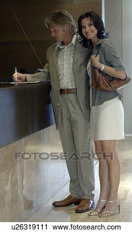 Stock Image - Couple at the hotel reception. Fotosearch