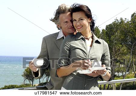 Stock Photo - Couple at the sea is drinking coffee. Fotosearch