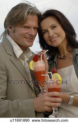 Stock Image - Couple at the sea with cocktails. Fotosearch
