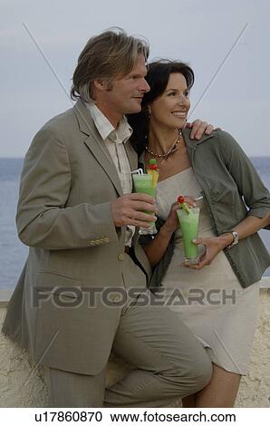 Stock Image - Couple at the sea with cocktails. Fotosearch