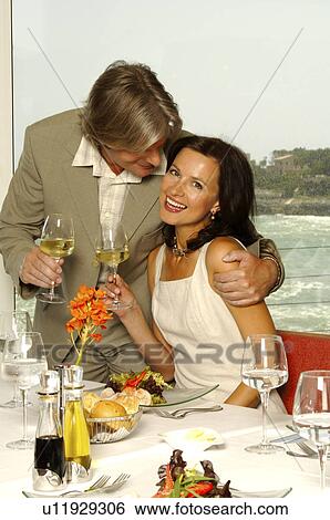Couple at the sea with wine glasses View Large Photo Image Stock Photograph - Couple at the sea with wine glasses. Fotosearch