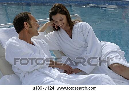 Picture - Couple in bathrobes at the swimming pool. Fotosearch