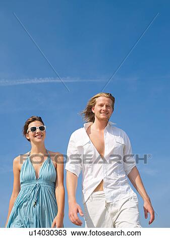 Couple in front of blue sky View Large Photo Image Stock Image - Couple in front of blue sky. Fotosearch