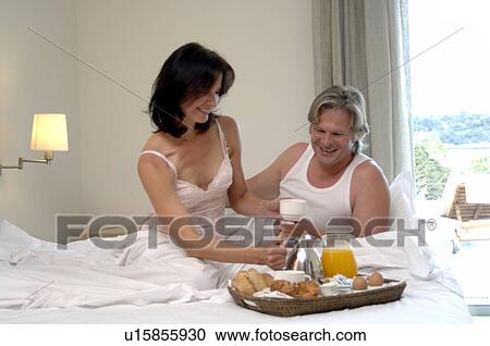 Stock Image - Couple is having breakfast in bed. Fotosearch
