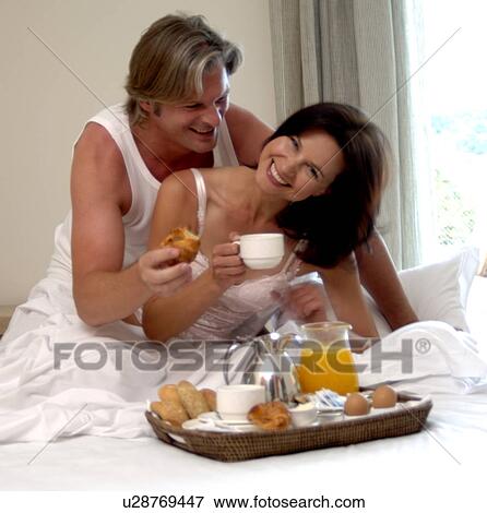 Couple is having breakfast in bed View Large Photo Image Stock Photo - Couple is having breakfast in bed. Fotosearch