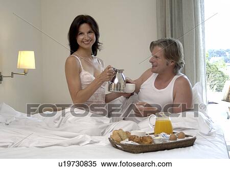 Couple is having breakfast in bed View Large Photo Image Stock Photography - Couple is having breakfast in bed. Fotosearch