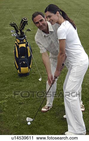 Stock Image - Couple is playing golf. Fotosearch
