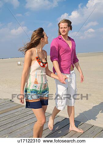 Stock Image - Couple on the beach promenade. Fotosearch