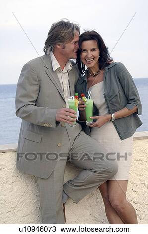 Stock Image - Couple with cocktails at the sea. Fotosearch