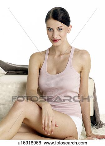 Stock Photo - Dark-red haired woman in underwear sitting on the floor. Fotosearch