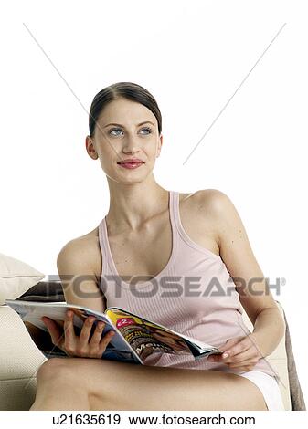 Stock Photo - Dark-red haired woman in underwear sitting on the floor reading a magazine. Fotosearch