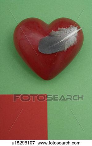 Stock Photo - Dark red heart and a feather. Fotosearch