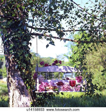 Stock Image - Decorated swing in garden. Fotosearch