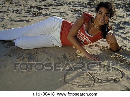 Stock Photo - Drawing a heart in the sand. Fotosearch