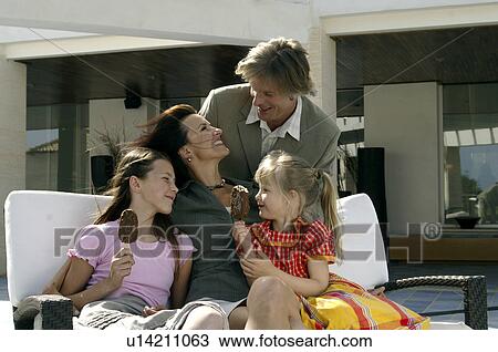 Stock Image - Family sitting on a bench. Fotosearch