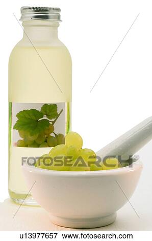 Stock Photo - Flasche Traubenkernöl aus weißen Weintrauben mit weißen Weintrauben im Mörser. Fotosearch