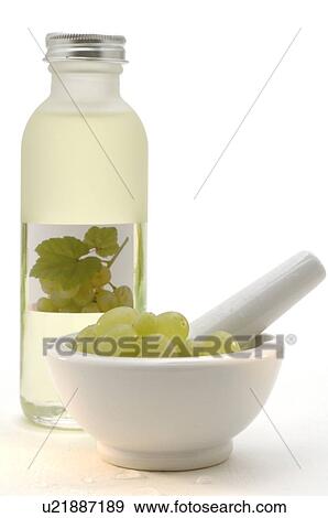 Stock Photo - Flasche Traubenkernöl aus weißen Weintrauben mit weißen Weintrauben im Mörser. Fotosearch