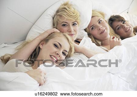 Four women in a white bed View Large Photo Image Stock Image - Four women in a white bed. Fotosearch