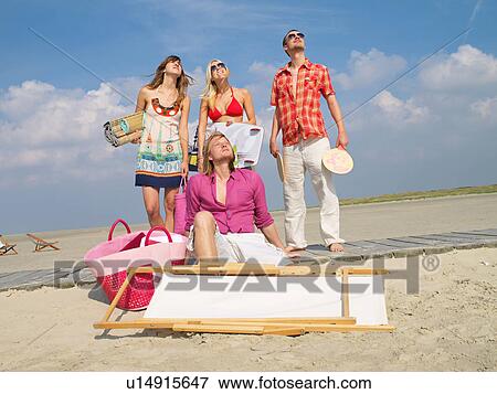 Stock Photo - Four young people on the beach. Fotosearch