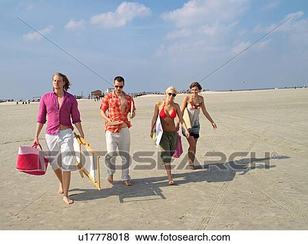 Stock Photo - Four young people on the beach. Fotosearch