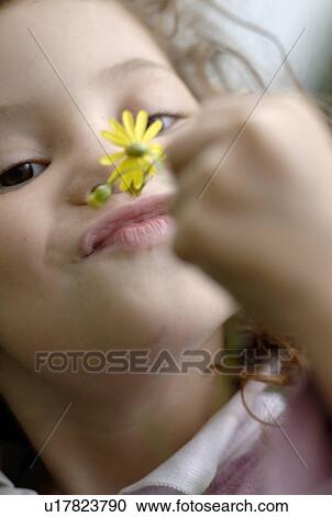 Stock Image - Girl looking at flower. Fotosearch