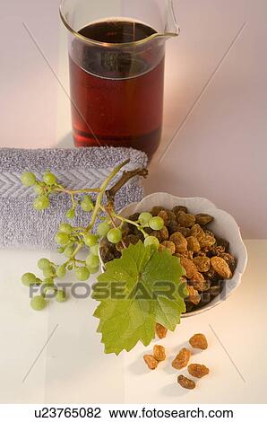 Stock Image - Glas mit Traubenkernöl aus roten Trauben und Rosinen in einer weißen Schüssel. Fotosearch