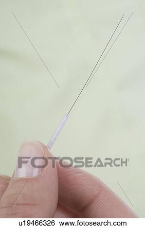 Stock Photograph - Hand holding acupuncture needle. Fotosearch