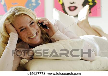 Happy teenage girl on couch using cell phone View Large Photo Image Stock Image - Happy teenage girl on couch using cell phone. Fotosearch