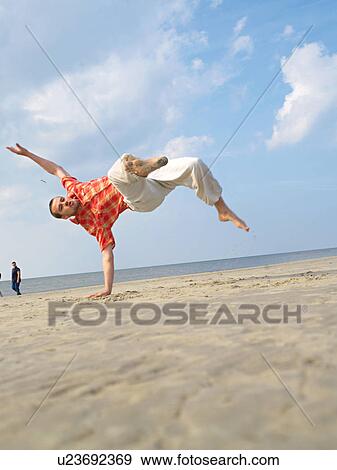 Stock Photo - Impressive jump on the beach. Fotosearch
