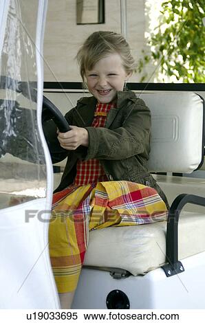 Stock Photography - Little girl at the steering-wheel of the hotel cart. Fotosearch