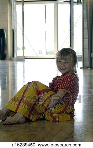 Stock Image - Little girl in a yellow and red checked dress. Fotosearch